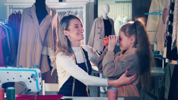 A Seamstress is Playing with Her Daughter at Work alt