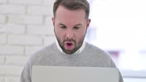 Close Up of Young Man Celebrating Success on Laptop alt