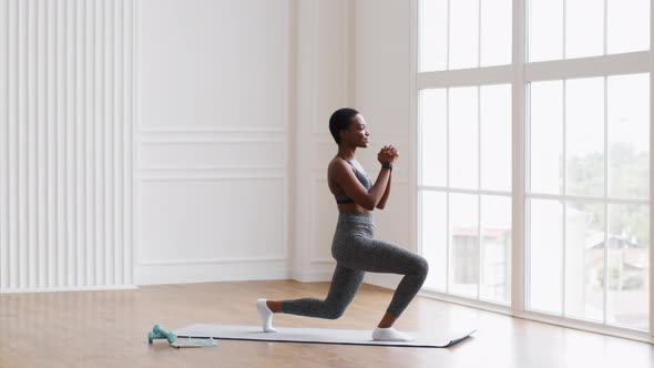 Sporty Black Woman Making Lunges Exercise While Training at Home alt