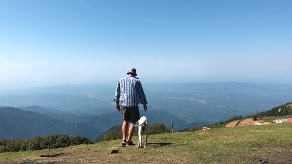 Man With Dog Walking on the Mountain