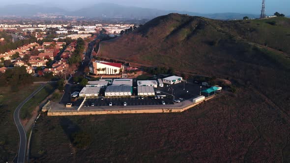 Aerial rotation around a church closer angle 2 at sunset in a suburban city. alt