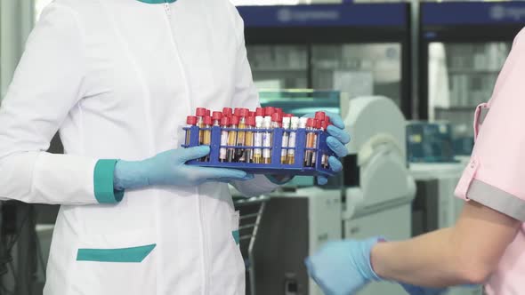 Cropped Shot of a Medical Worker Receiving Blood Test Samples from a Colleague alt