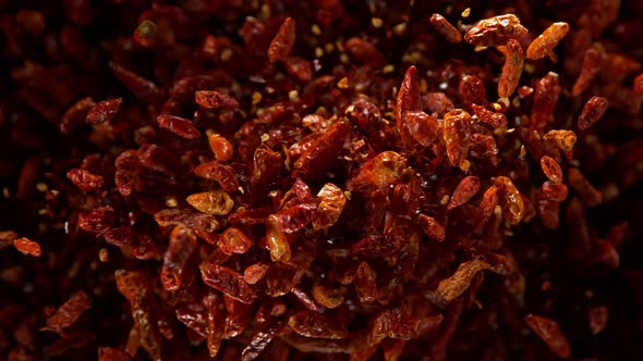 Super Slow Motion Shot of Dried Red Chili Peppers Explosion on Black Background at 1000Fps alt
