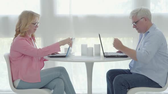 Side View of Confident Senior Freelancer Opening Laptops and Start Working Online. Positive Mid alt