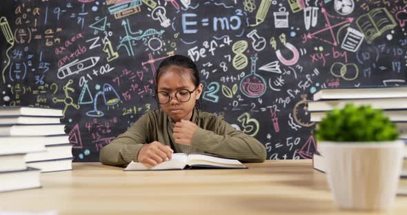 Girl kid reading at desk with chalkboard background alt