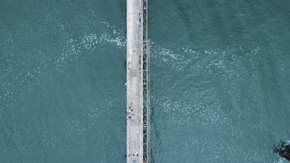 Unique view following high above old abandon wharf surrounded by the ocean waters. Drone view alt