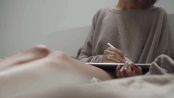 Close Up Shot of a Woman Hands Working on a Portable Tablet Sitting on a Couch alt