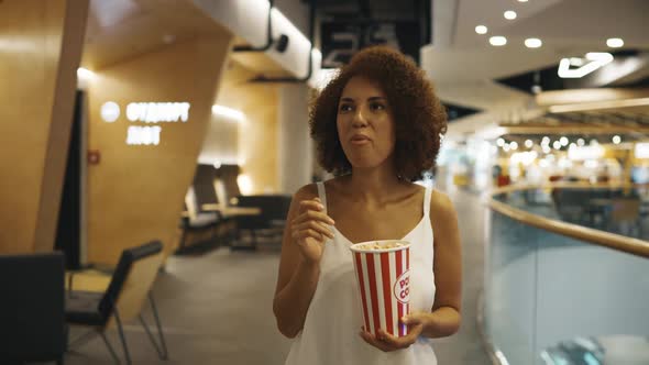 A Young Woman with Popcorn Came to a Movie Screening in the Cinema alt