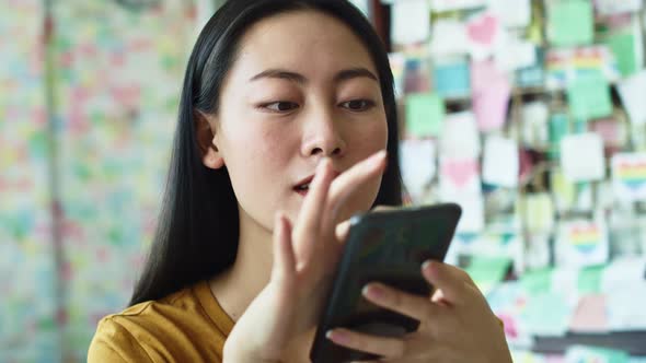 Handheld view of Vietnamese woman with cell phone at cafe. Shot with RED helium camera in 8K alt