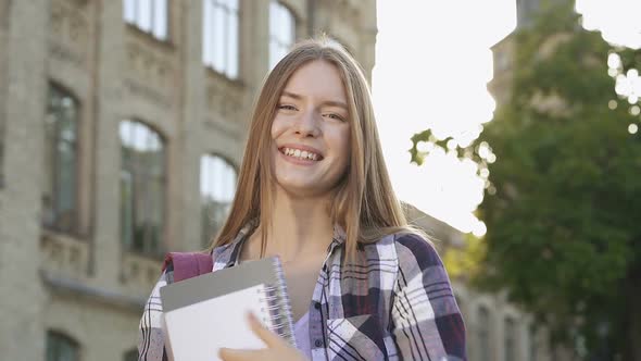 Portrait of Happy and Smiling Student Girl Standing Near the College Building