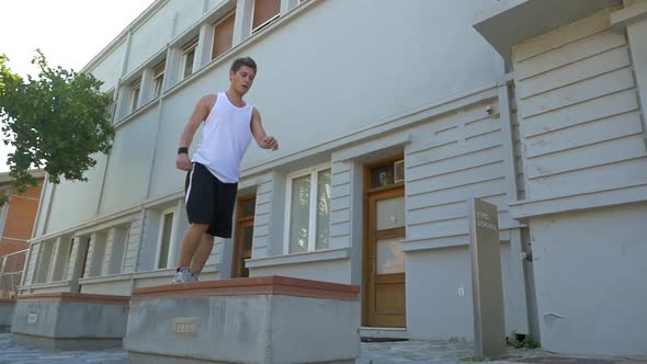 Young athlete performing parkour trick alt