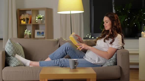 Happy Smiling Pregnant Woman Reading Book at Home alt