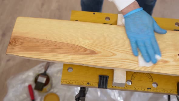 the Carpenter Rubs the Wood with Oil with a Napkin alt