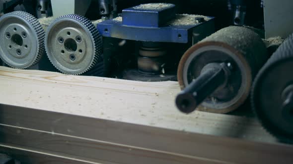 Industrial Mechanism with Revolving Gears Is Scraping Wood alt