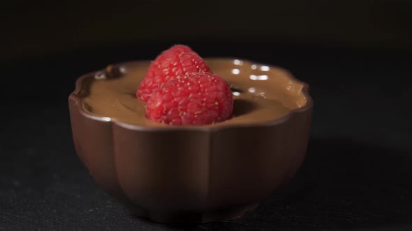 Raspberries Splashing Into Liquid Dark Chocolate in Slow Motion