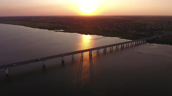 Aerial Shot of a Lengthy Bridge at Splendid Sunset From a High Flying Drone
