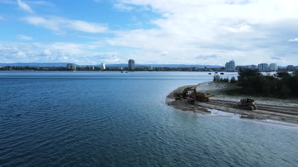 Large mining machines working on the edge of an island dredging sand from a ocean boating channel. H alt