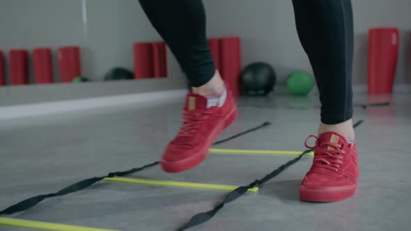 Young man is engaged in crossfit, doing leg exercises, warming up, in the gym. alt