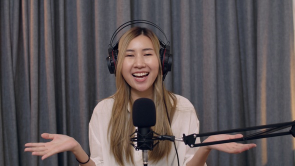 Asian woman influencer recording a vlog using podcast microphone.