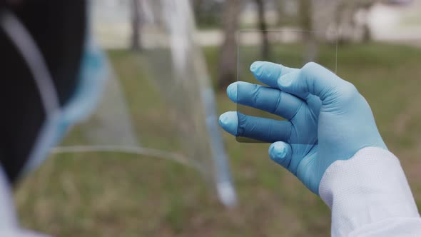 Man with the Face Shield and Medical Masks, Holding Glass, Like a Virtual Screen. Pandemic Concept alt