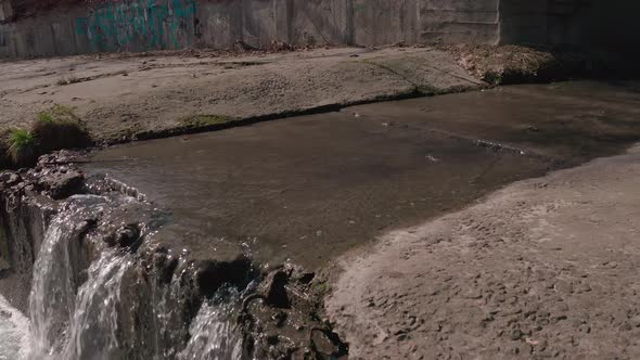 The River Flowing in a Concrete Reservoir in the City alt