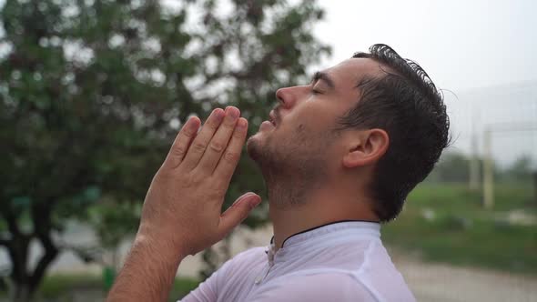 Young Religious Man Says a Prayer Standing Outside alt
