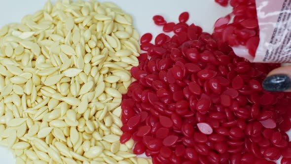 Red granules of depilatory wax. Sugaring. Depilation. Epilation. Beauty concept. alt