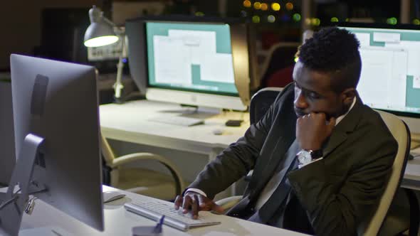 Young Office Worker Working on Computer at Night alt