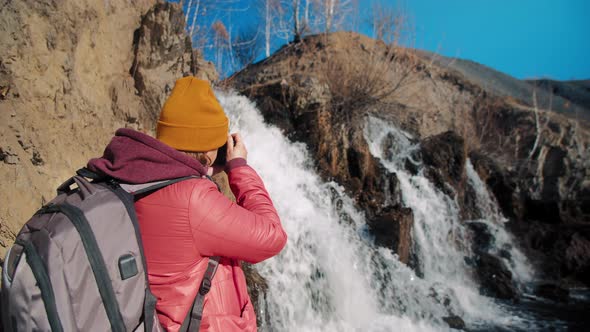Woman Takes Photo of Waterfall alt