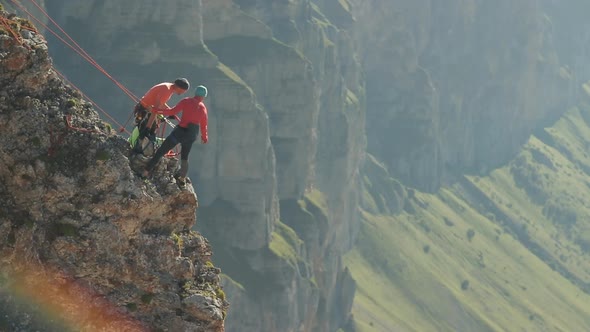 A Group of Climbers Discussing a Plan of Action Standing on the Edge of the Cliff
