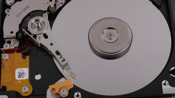 Opened Hard Disk Drive with Spinning Platter. Move of Writing Magnetic Head alt
