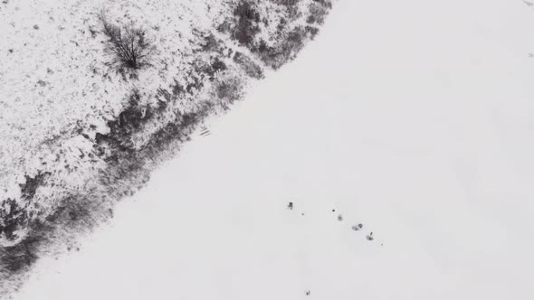 Man is drilling ice with ice drill on frozen lake alt