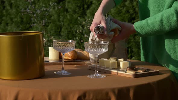 Female in green sweater cut bread for snacks for outdoor party alt