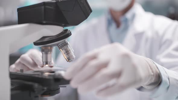 Researcher scientist using microscope to work in biotechnology laboratory medicine science biology alt