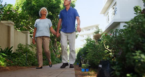 Senior couple walking in the garden alt