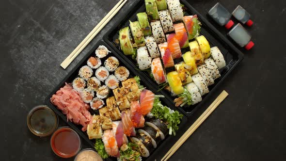 Asian Food Delivery Home Various Sushi Sets in Plastic Containers with Sauces Rice and Chopsticks