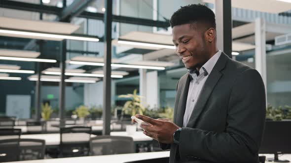 Happy Millennial Man African American Male Businessman Employee Adult Guy Hold Cellphone Chat in alt