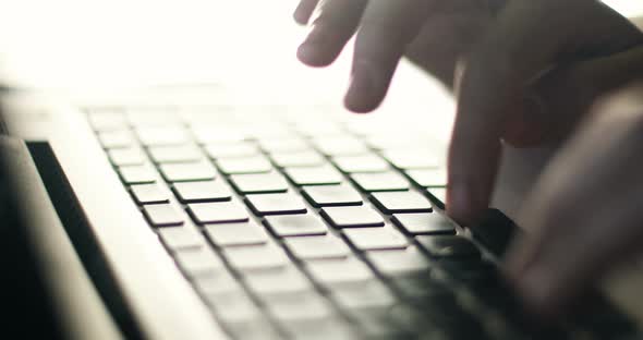 Woman typing at a laptop keyboard