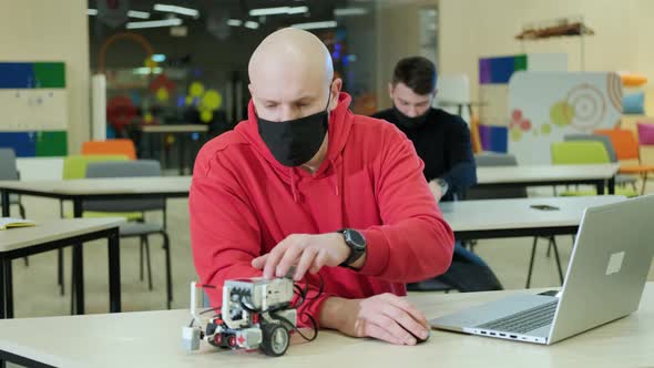 Robotics Teacher Who Teaches an Online Course for His Students Using a Computer alt