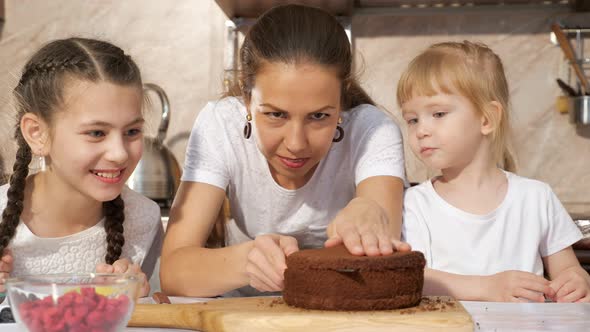Happy Family Mom and Daughters Are Cooking Birthday Cake Together alt