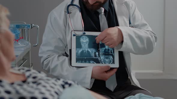 Doctor Showing Tablet with Radiography for Sick Woman in Bed alt