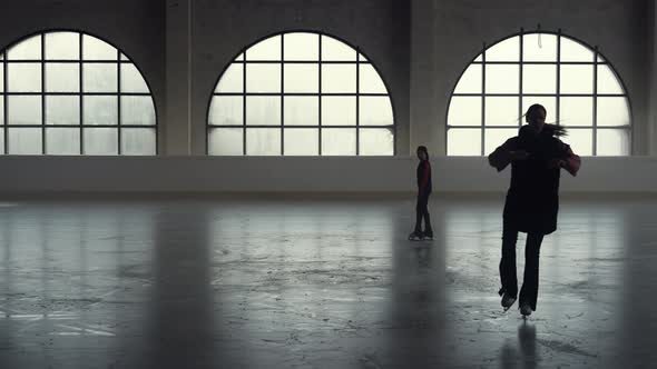Woman Coach Shows Her Girl Student Elements of Figure Skating Choreography alt