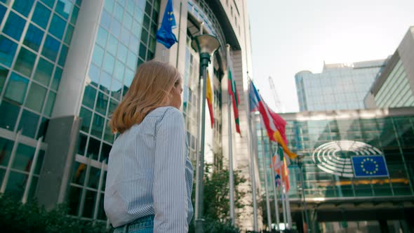 Woman Walks Along EU Flags to European Parliament Office in Brussels Belgium