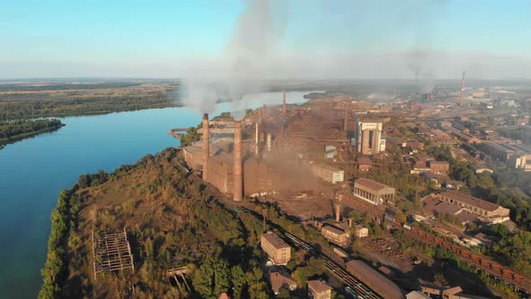 Aerial View of the Industrial Plant with Smoking Pipes Near the City alt