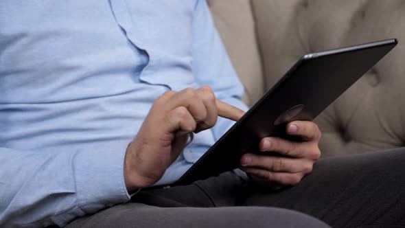 Close Up Hands Man Trader Broker Uses Tablet to Track Quotes on Stock Exchanges alt