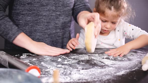 Mother and daughter baking sugar skull cookies for Dia de los Muertos holiday. alt