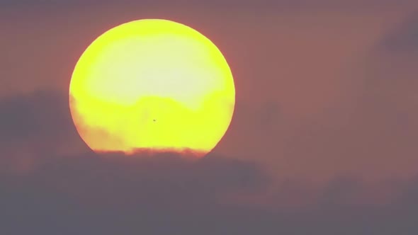 Time Lapse a Large Sun with Spot Sets in Dark Clouds alt