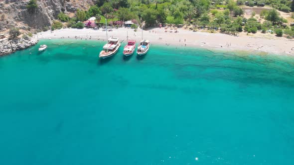 4k Aerial view of Butterfly valley beach and boats, Yacht stationed on the beach in Fethiye Turkey, alt