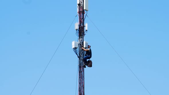 Electrician repairman repairs a mobile communication antenna. Repair work to restore wireless