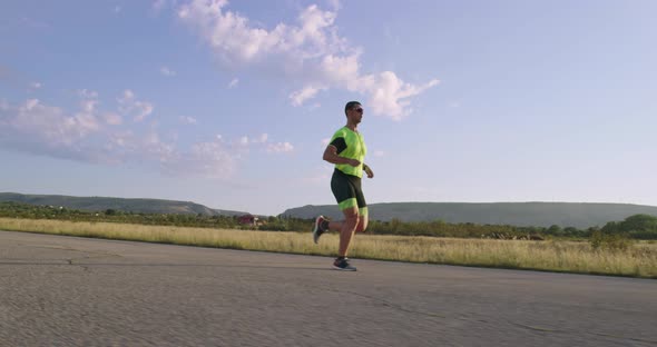 Triathlon  Male Triathlete Running in Triathlon Suit Training for Ironman Race alt